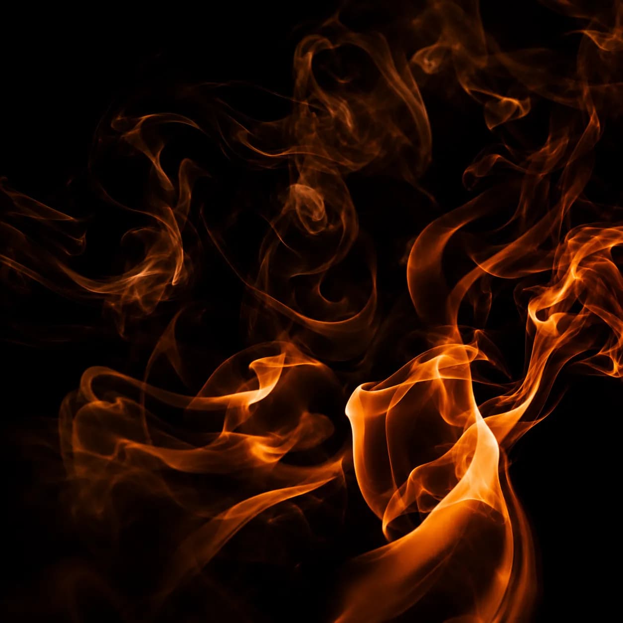 Humo y llamas anaranjadas sobre un fondo negro.